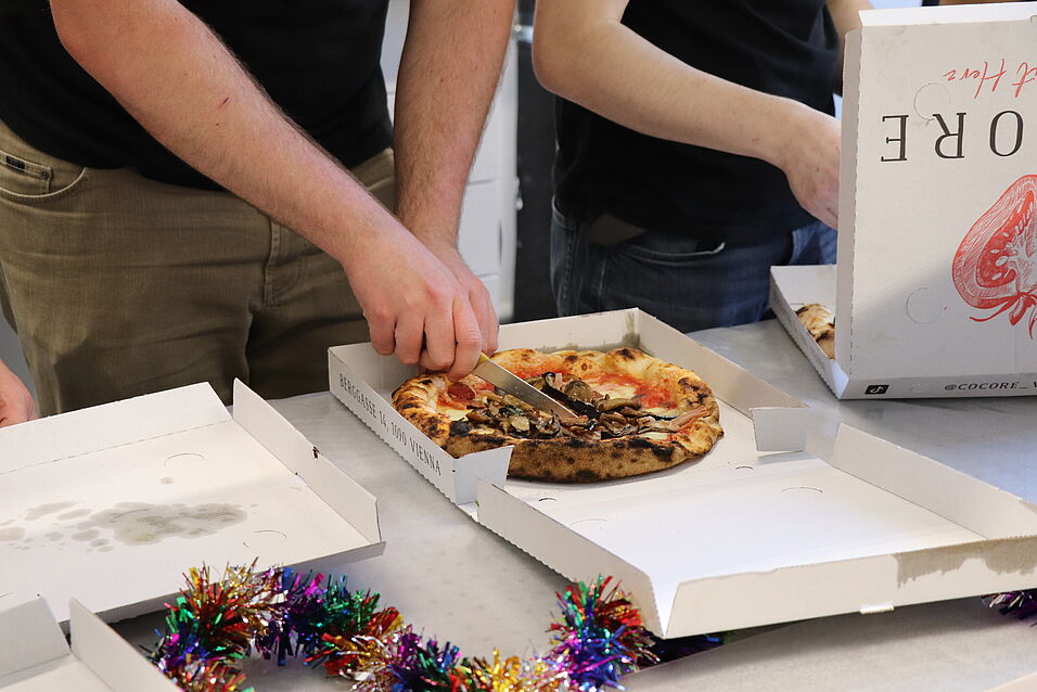 A pizza getting cut.