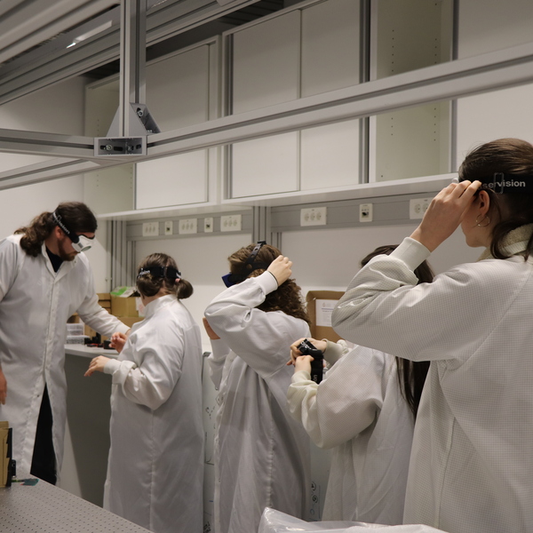 The participants trying on labcoats and laser goggles before going into the lab.